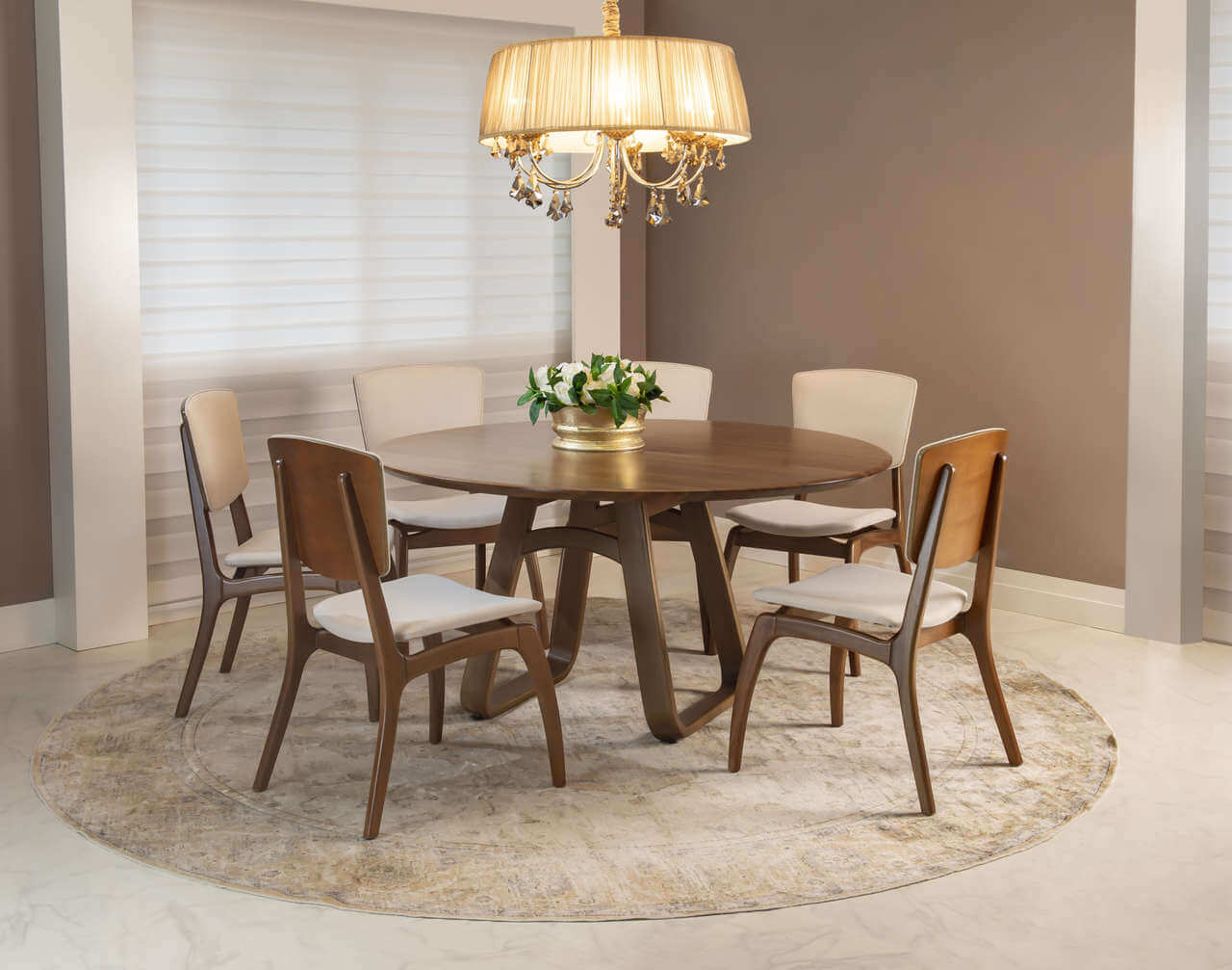 Sala de jantar com mesa redonda, cadeiras, luminária e tapete redondo