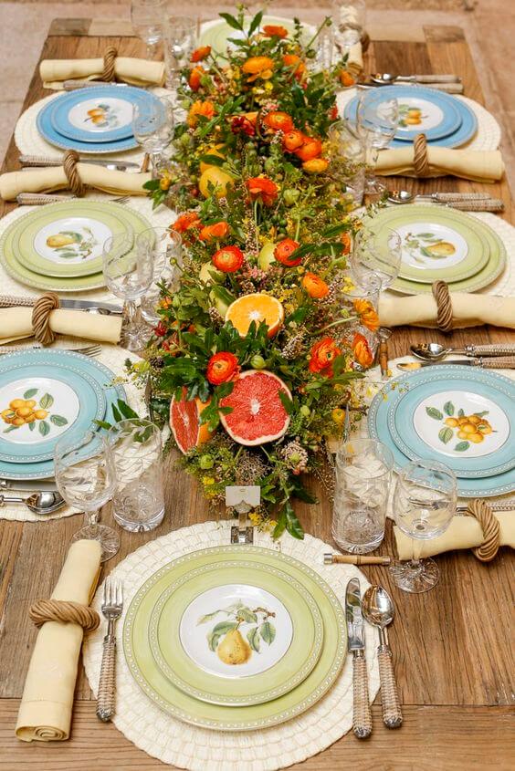 mesa posta com flores e frutas cítricas