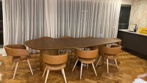 sala de jantar com mesa orgânica e cadeira em couro