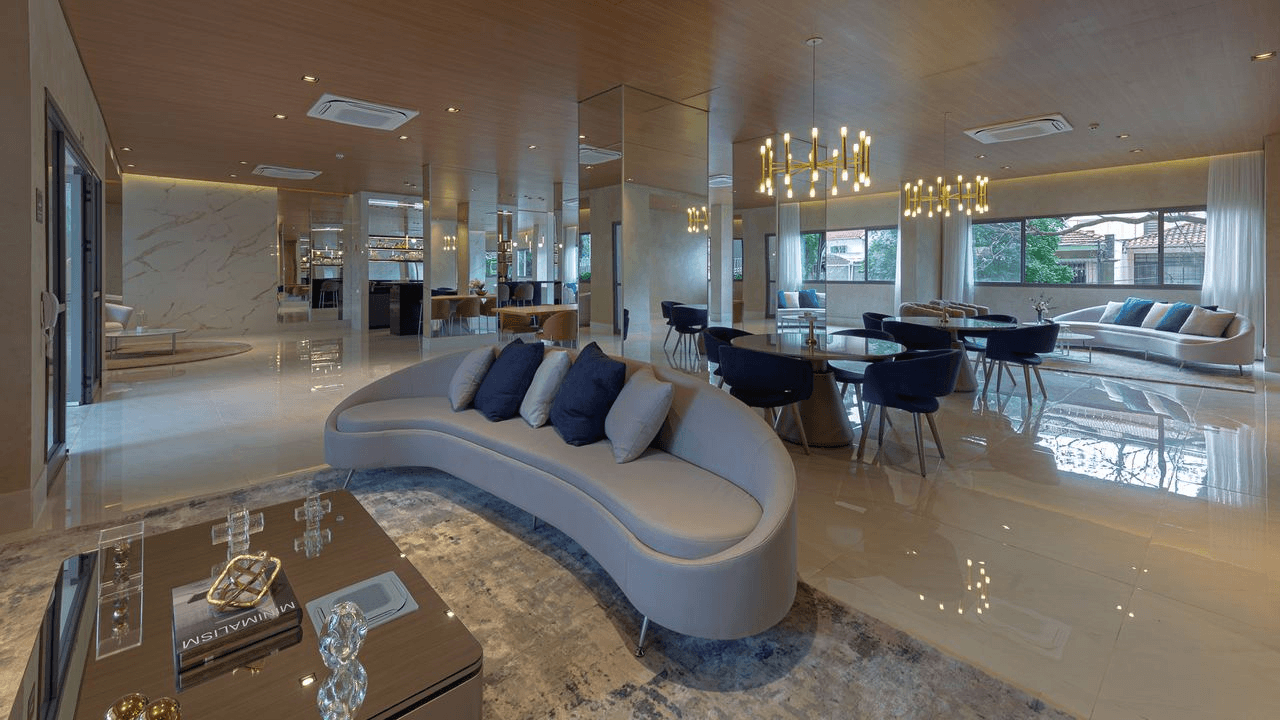 Valorização imobiliária: o papel do mobiliário na venda 2 Salão de festas do empreendimento Grand Square, da LAVVI, com sofá curvo e mobiliário contemporâneo.