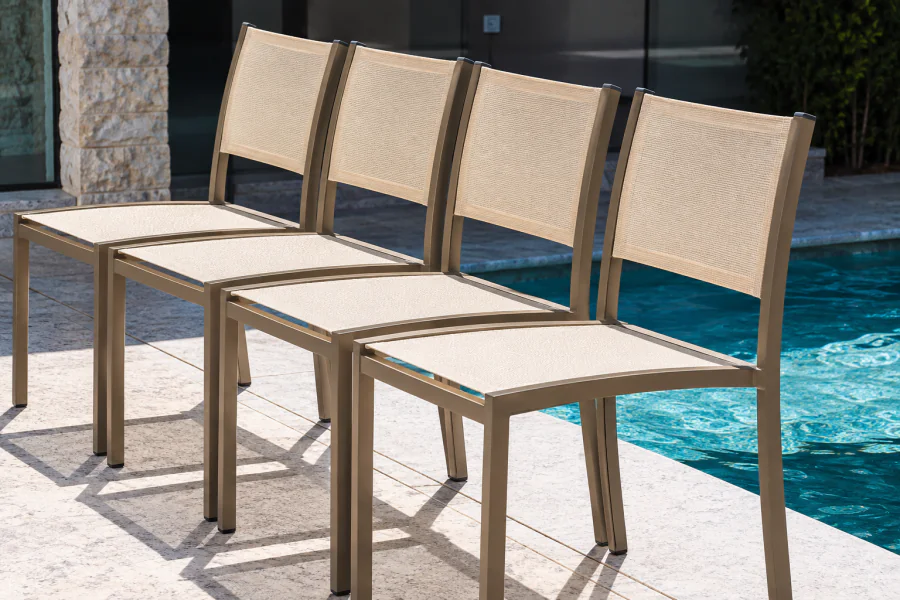 Quatro Cadeiras Área Externa Belmonte com estrutura em alumínio Fendi Fosco e assento e encosto em Tela Sling Bege, alinhadas à beira da piscina em ambiente externo contemporâneo.