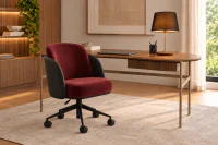 Cadeira de Escritório Elian em vista 3/4, em ambiente de home office, com encosto arredondado, braços integrados e base metálica Preto Fosco com pistão a gás para regulagem de altura.