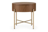 Mesa de Cabeceira Redonda em Madeira Avila com acabamento em Cinamomo Castanho, gaveta fechada e estrutura metálica Champagne Metalizado com travessas cruzadas em X, sobre fundo branco.