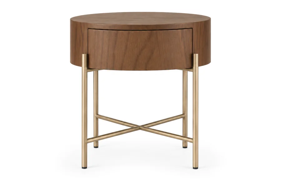 Mesa de Cabeceira Redonda em Madeira Avila com acabamento em Cinamomo Castanho, gaveta fechada e estrutura metálica Champagne Metalizado com travessas cruzadas em X, sobre fundo branco.