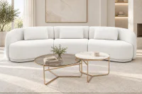 Sofá Curvo Mury de três módulos em Bouclê Branco, com design orgânico e linhas arredondadas, ambientado em sala de estar contemporânea sofisticada, acompanhado por mesas de centro redondas com estrutura metálica champanhe, tapete claro e decoração em tons neutros.