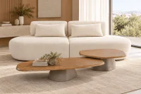 Sofá Curvo Orgânico Galena em bouclé off white, com dois assentos arredondados e almofadas soltas, ambientado em sala de estar contemporânea com mesas de centro orgânicas em madeira e bases de concreto, tapete bege e decoração em tons neutros.